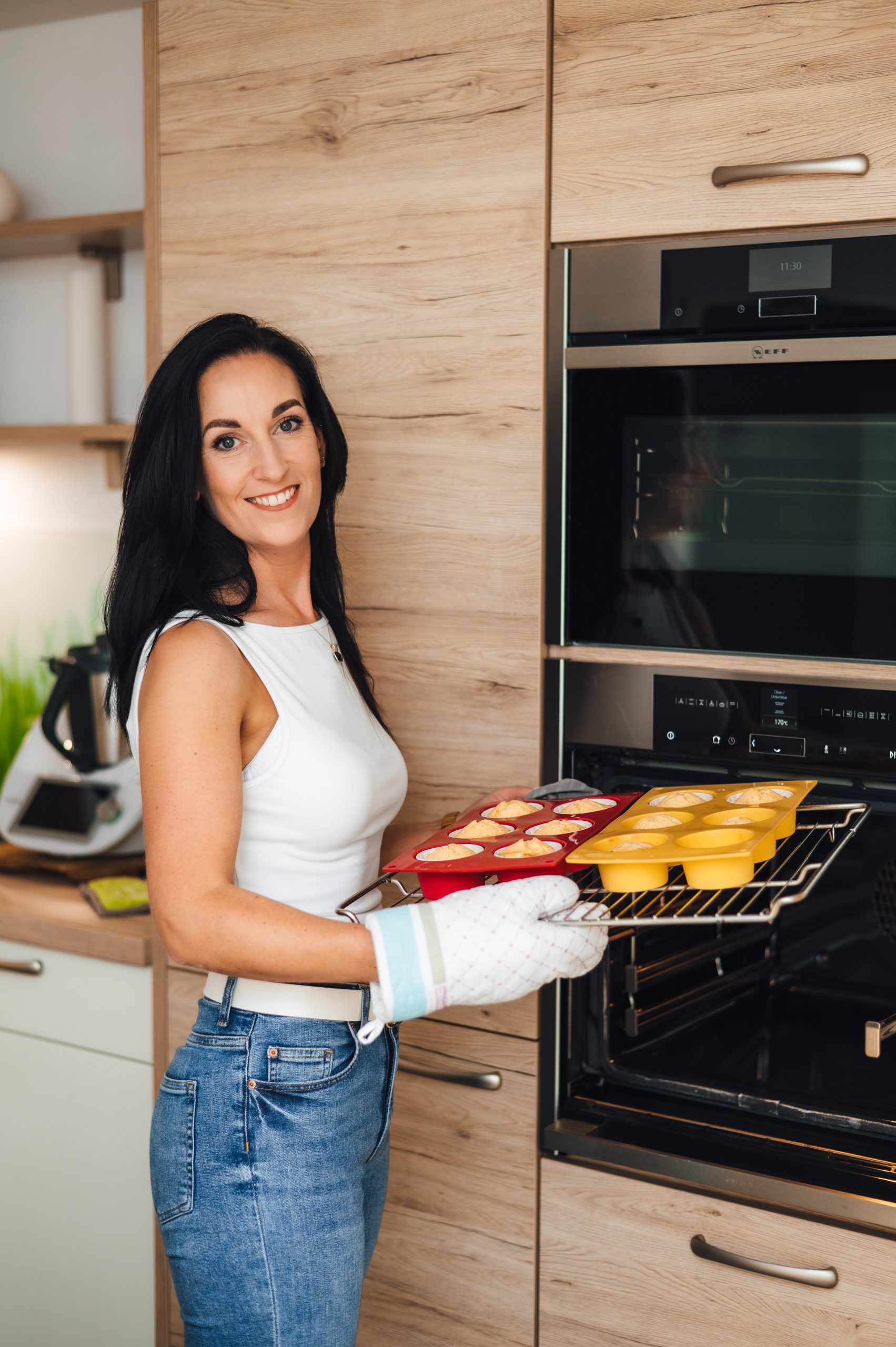 Sarah Sangermann nimmt frische Cupcakes aus dem Ofen in ihrer modernen Küche