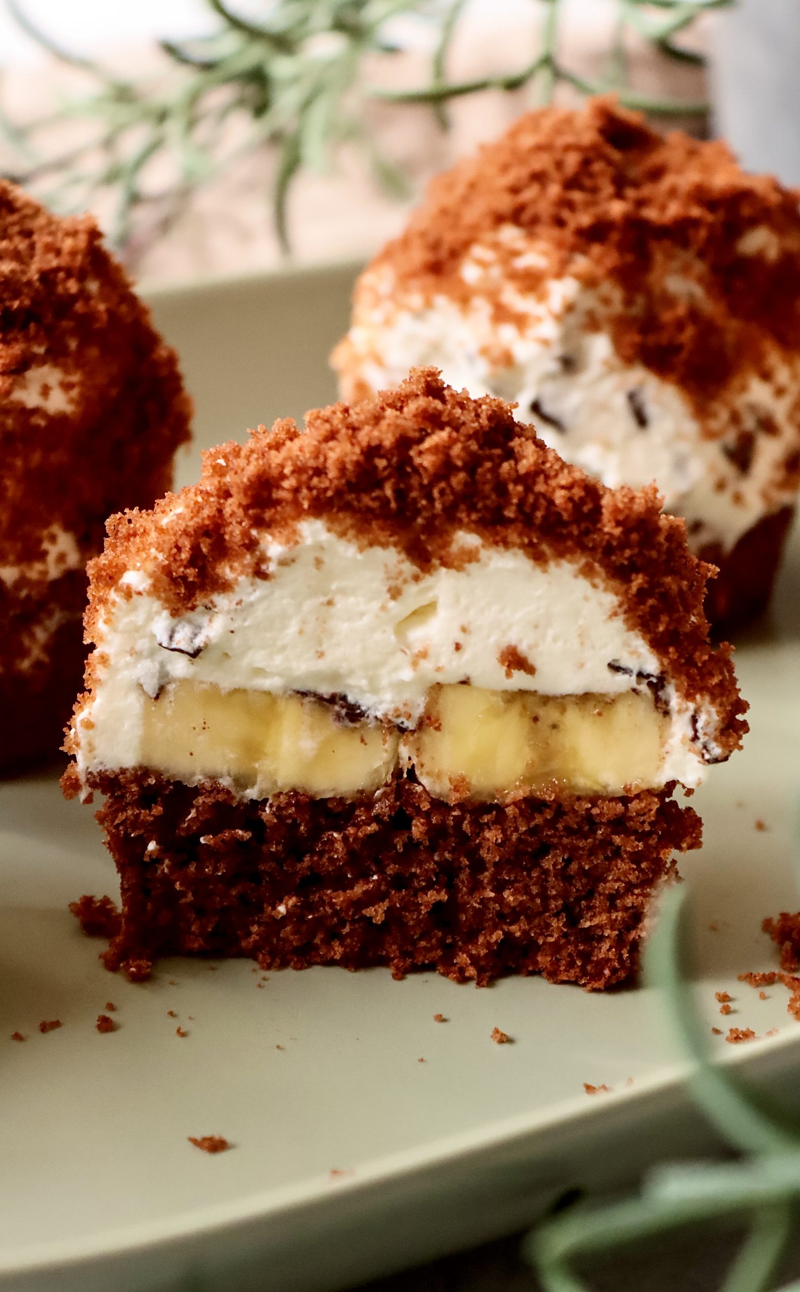 Banana Split Cupcakes mit Banane, Sahnecreme und Schokoboden im Anschnitt