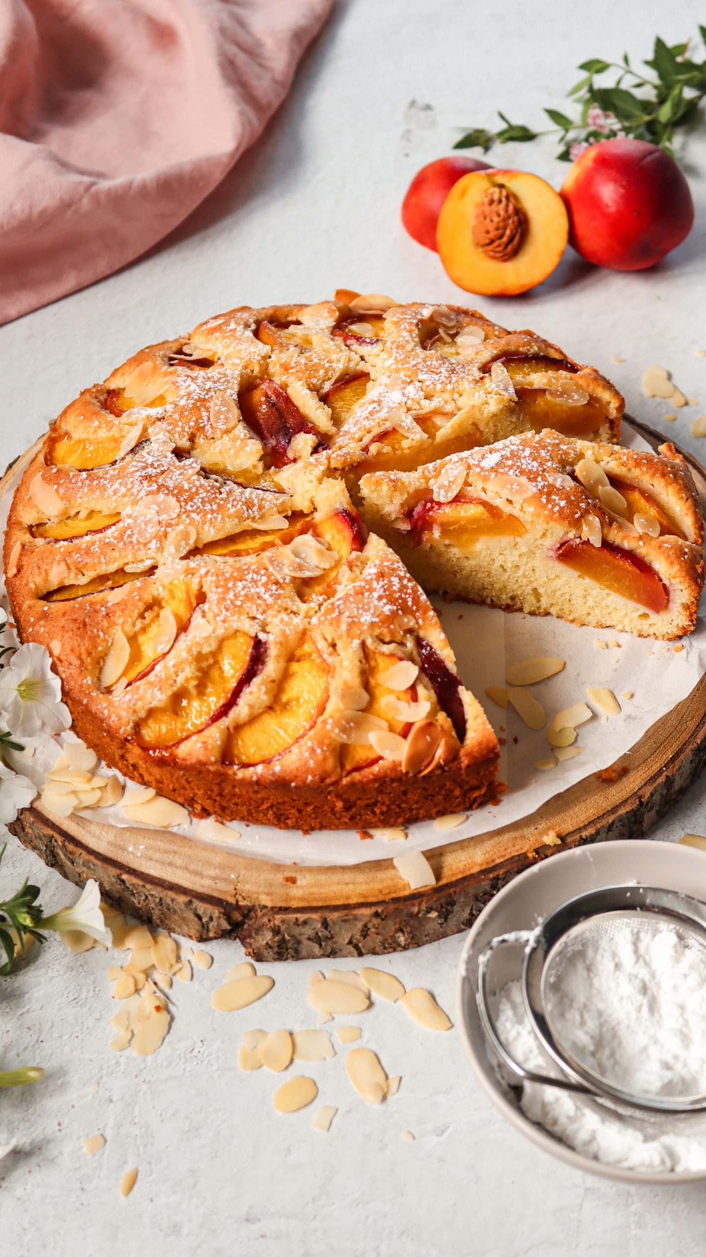 Home Angeschnittener Nektarinenkuchen mit saftigen Früchten und Mandelblättchen
