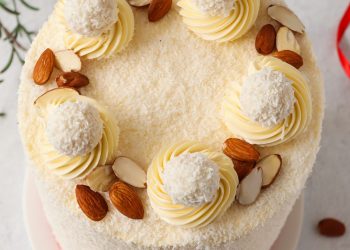 Raffaello Torte mit Kokos und luftiger Creme Raffaello Torte von oben mit Kokosraspeln, Raffaello Pralinen und Cremetuffs