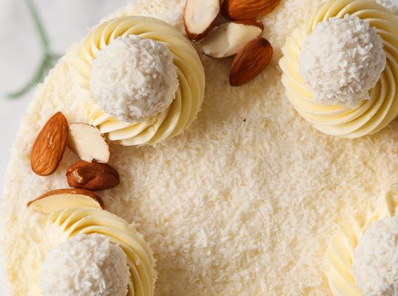 Draufsicht auf eine hohe Raffaello Torte mit Kokosraspeln, Mandeln und Raffaello Pralinen
