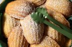 Frisch gebackene Madeleines mit goldbrauner Kruste auf einem Teller