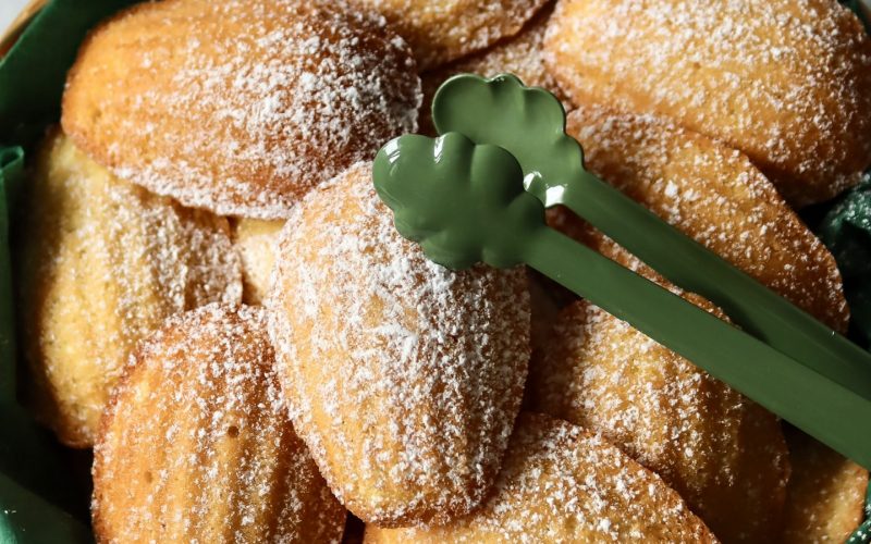 Frisch gebackene Madeleines mit goldbrauner Kruste auf einem Teller