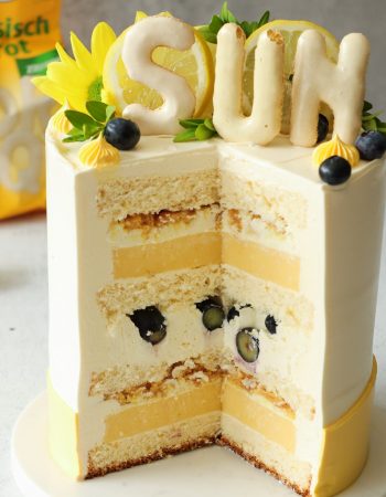 Anschnitt einer Zitronentorte mit Lemon Curd, Heidelbeeren und knusprigem Russisch-Brot-Crunch