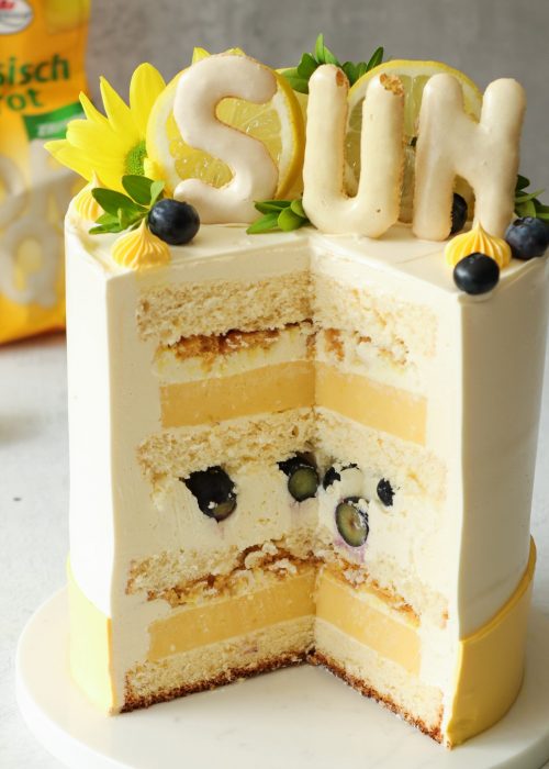 Anschnitt einer Zitronentorte mit Lemon Curd, Heidelbeeren und knusprigem Russisch-Brot-Crunch
