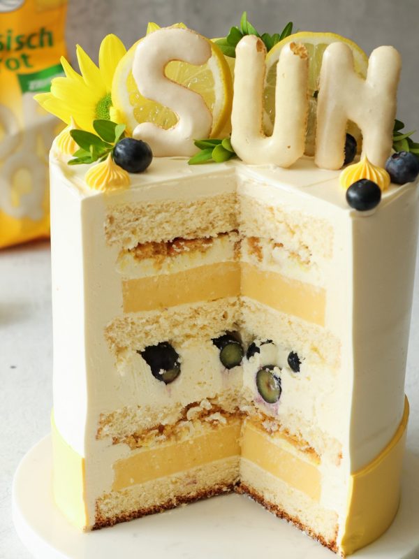 Anschnitt einer Zitronentorte mit Lemon Curd, Heidelbeeren und knusprigem Russisch-Brot-Crunch