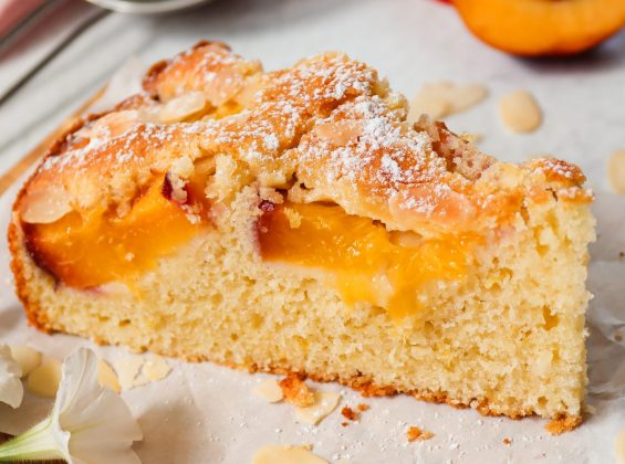 St&uuml;ck saftiger Nektarinen-Mandelkuchen auf einem Teller