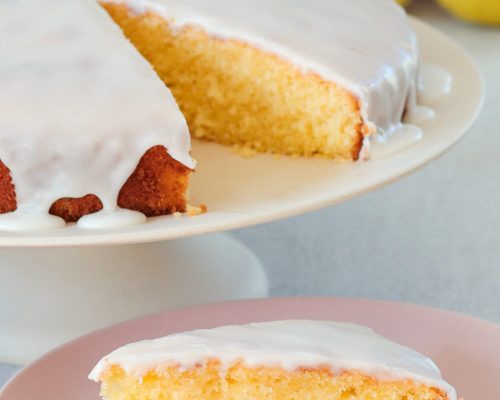 Saftiger Zitronenkuchen mit Zitronenguss Saftiger Zitronenkuchen mit Zitronenguss auf rosa Teller angeschnitten serviert