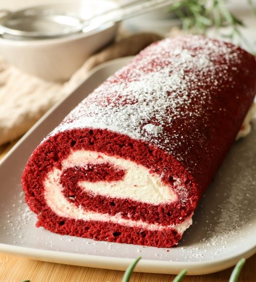 Red Velvet Biskuitrolle mit heller Cremef&uuml;llung, sauber aufgerollt und dekorativ angerichtet